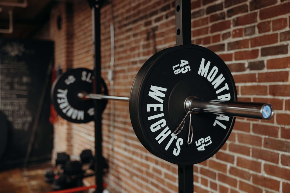 barbell and weight plates on squat rack